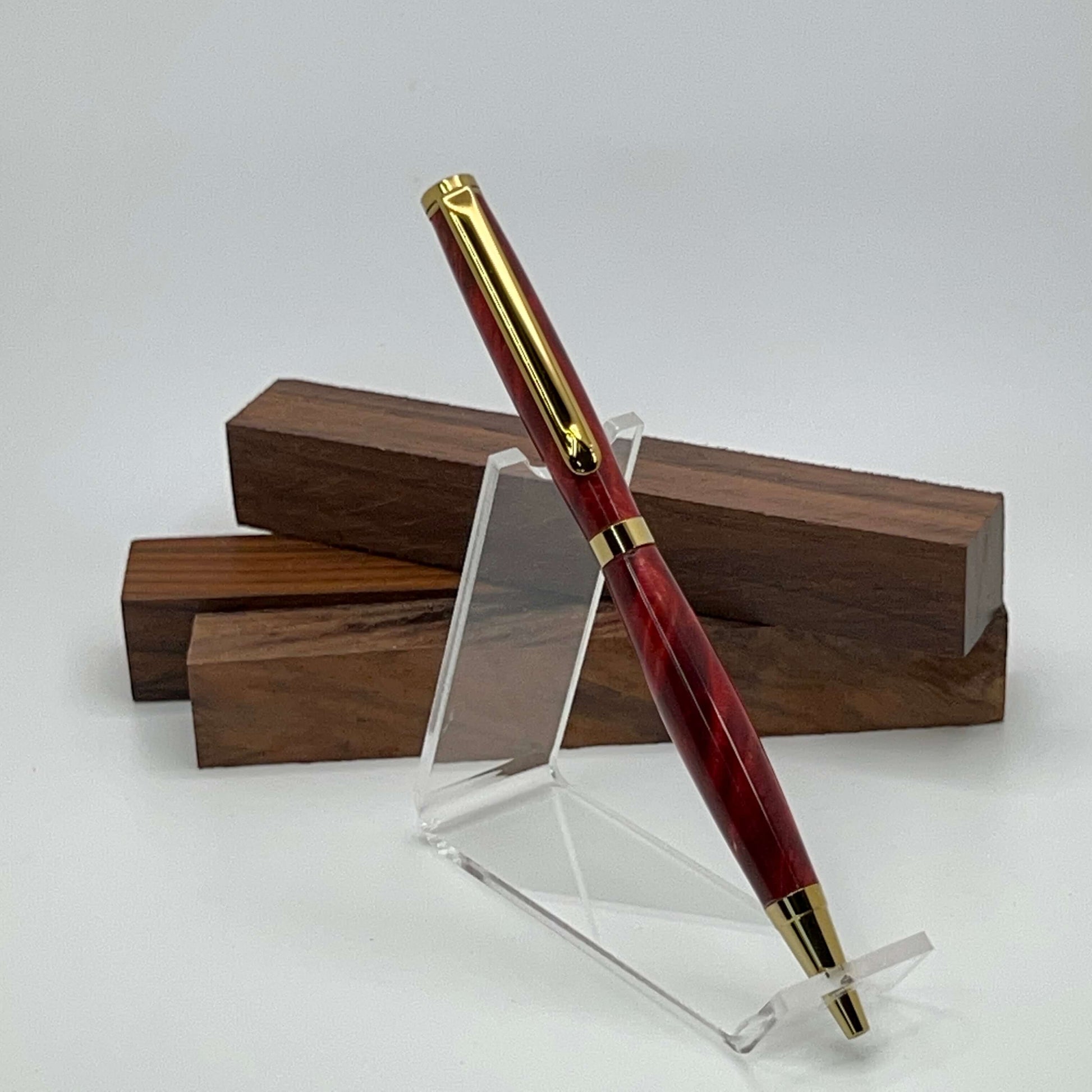 Handcrafted pen with Box Elder Burl wood dyed red and gold titanium hardware