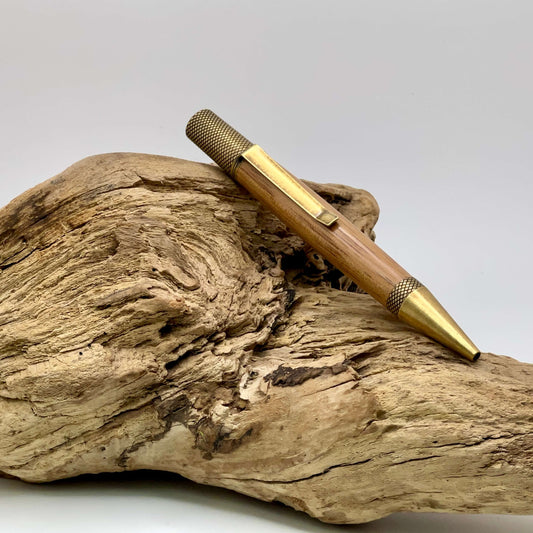 Exemplar antique brass twist ballpoint pen setting on driftwood