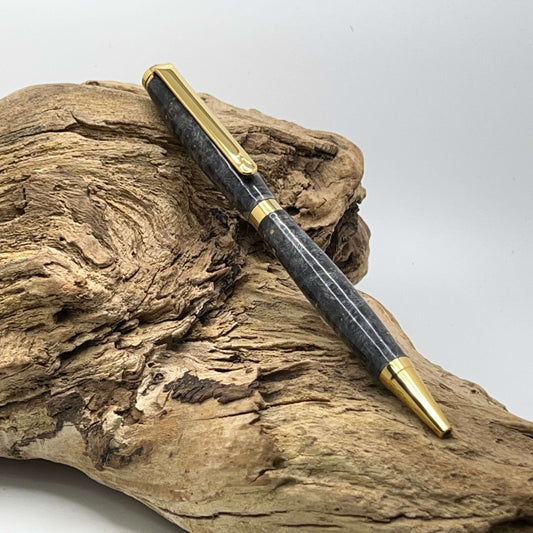 Handcrafted Box elder wood pen dyed black setting on driftwood
