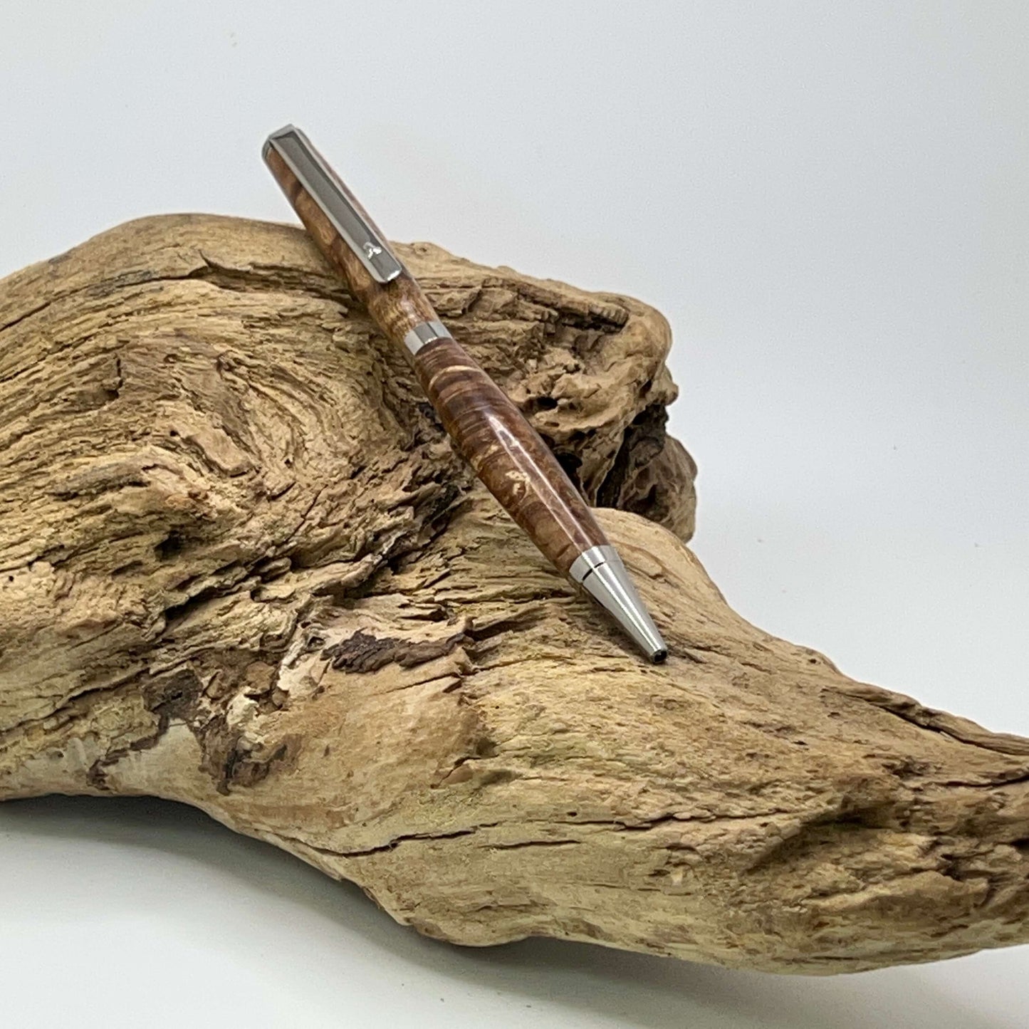 Handcrafted Box elder wood pen dyed brown setting on driftwood