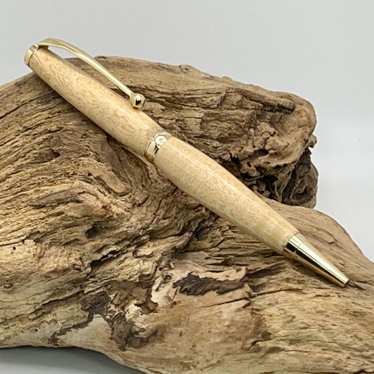 Handcrafted Wood Apple wood pen with gold hardware setting on driftwood
