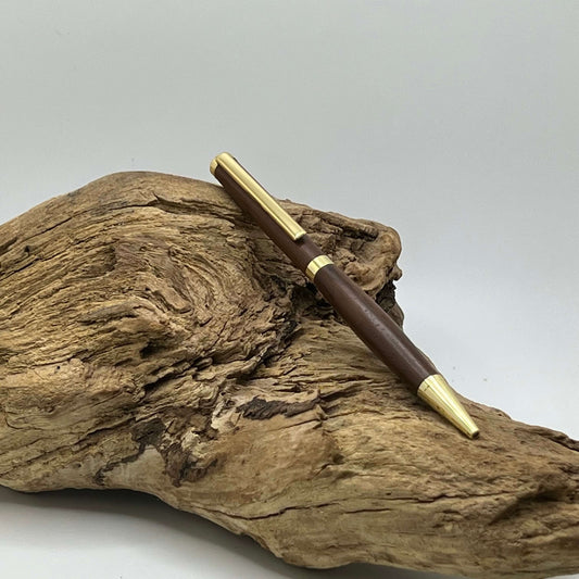 24kt gold clad slimline pen with walnut wood setting on driftwood 