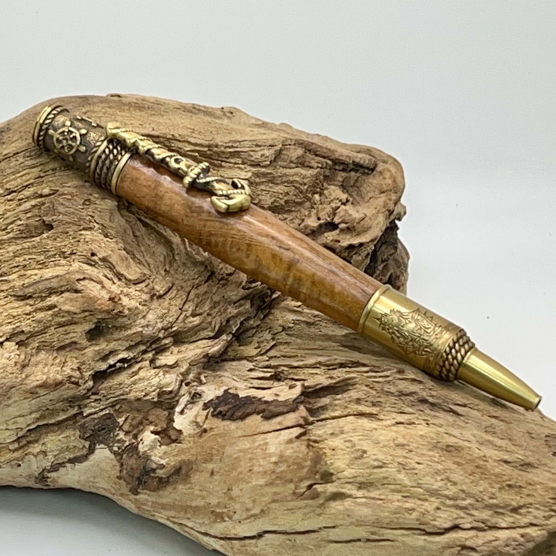 Nautical teak wood twist style ballpoint pen. Features antique brass anchor clip, ships wheel, and compass. Engraved sailing ship.